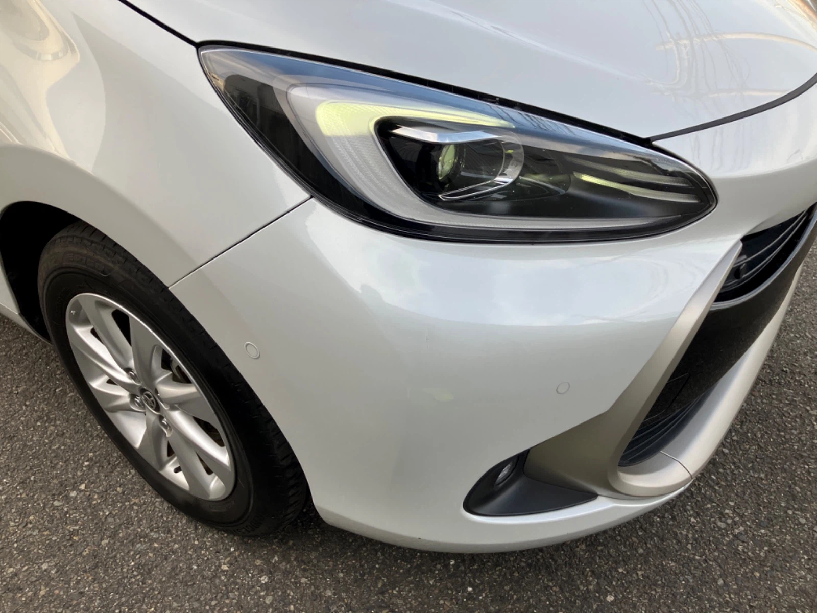 傷の画像です。フロントバンパーのやや目立つ位置に凹みを伴うキズがあります。